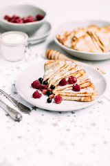 Pancakes with wild berries in a plate.Maslenitsa