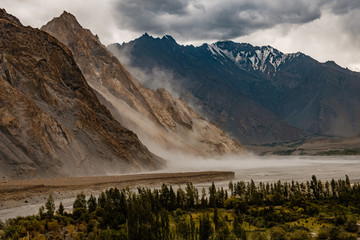 windy dust storm on a riven in mountains