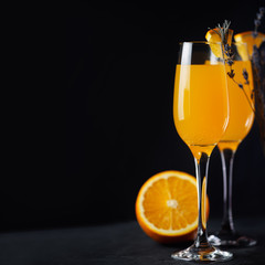 Mimosa cocktail with orange and champagne on a dark background copy space