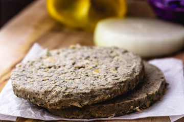 raw soy vegan burger, without frying, on wooden background.Vegan food and healthy living concept.