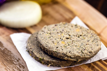 raw soy vegan burger, without frying, on wooden background.Vegan food and healthy living concept.