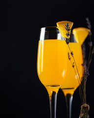 Mimosa cocktail with orange and champagne on a dark background