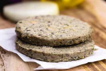 raw soy vegan burger, without frying, on wooden background.Vegan food and healthy living concept.