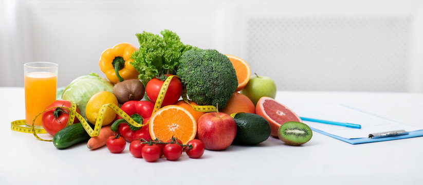 Nutritionist's workplace with fruits, vegetables, measuring tape on table
