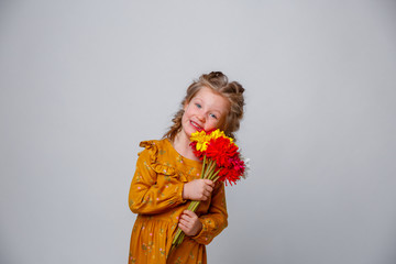 portrait of a smiling child a blonde girl with a bouquet of flowers isolated on a white background