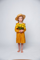 child little girl in a straw hat hold bouquet of spring flowers, isolated on a white background. Child girl hold bouquet of yellow tulips