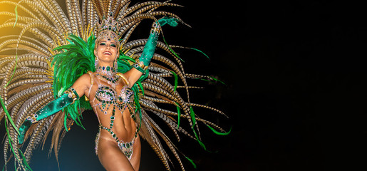 Brazilian wearing Samba Costume. Beautiful Brazilian woman wearing colorful costume and smiling during Carnaval street parade in Brazil. - obrazy, fototapety, plakaty