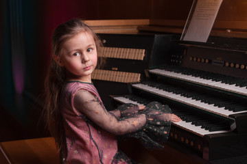 Little girl playing a pipe organ