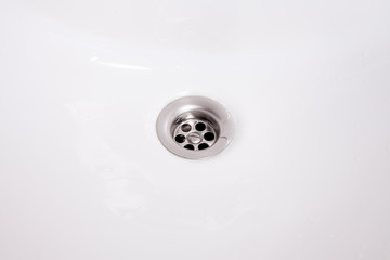 View of the sink, drain and flowing water for background