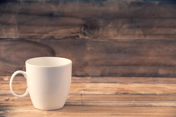 White mug on the wooden table and copy space