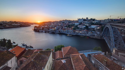 Fototapeta premium Panorama old city Porto at river Duoro,with Port transporting boats at sunset timelapse, Oporto, Portugal