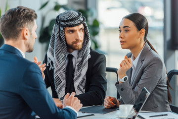 multicultural business partners talking on meeting with translator in office