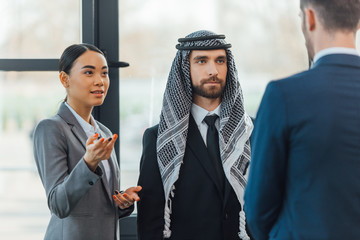 multiethnic business partners on meeting with translator in office