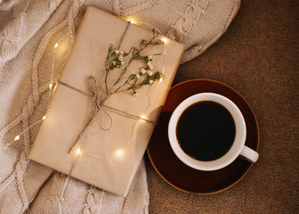 A cup of coffee and a book on a plaid. Sweet home. Good morning. Reading and home relaxation concept. Top view, flatlay