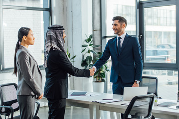 professional multiethnic businesspeople shaking hands on meeting with translator in office