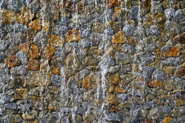 Waterfall on stone background at swimming pool,motion blur.