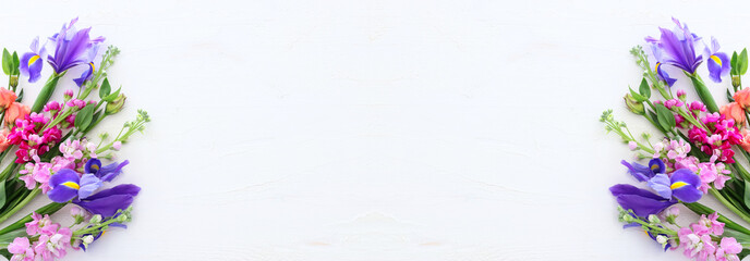 spring bouquet of pink and purple flowers over white vintage wooden background. top view, flat lay