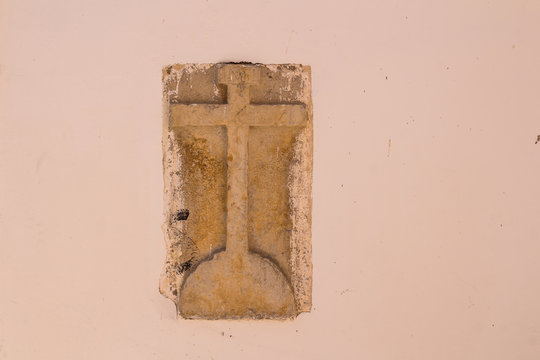 Stone cross in a wall of a building