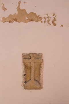Stone cross in a wall of a building