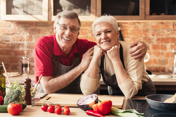 Portrait of smiling aged couple posing in kitchen