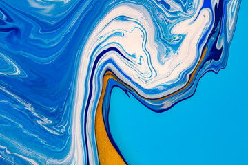 Fluid art texture. Abstract background with mixing paint effect. Liquid acrylic artwork that flows and splashes. Mixed paints for background or poster. Blue, golden and white overflowing colors.