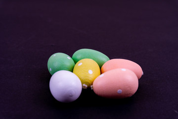 Close up of a few colorful easter eggs laying on black background