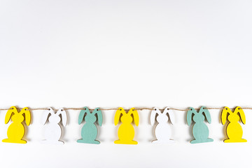 A row of colorful easter bunnies on white background with copy space