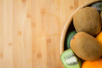 Bowl with kiwi oranges and avocados on the right side