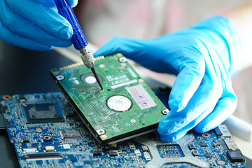 Asian Technician repairing micro circuit main board computer electronic technology : hardware,...