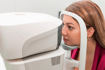 Measuring young woman's eye pressure with tonometer
