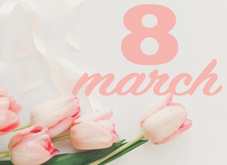 8 march. Happy womens day greeting card. 8 march text on pink tulips with ribbon on white background. Stylish tender image. Handwritten text, lettering