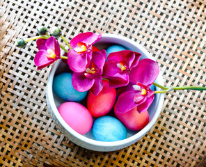 easter eggs and flowers on wicker basket background