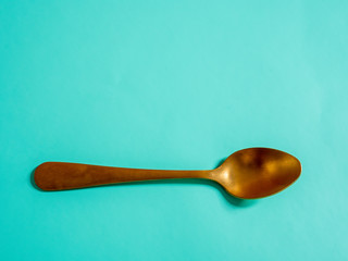 yellow metal spoons imitating gold on a blue background