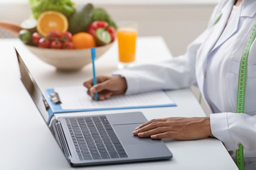 Nutritionist working online, writing down client history