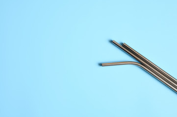 reusable metal stainless steel drinking straws on a blue background. space for text
