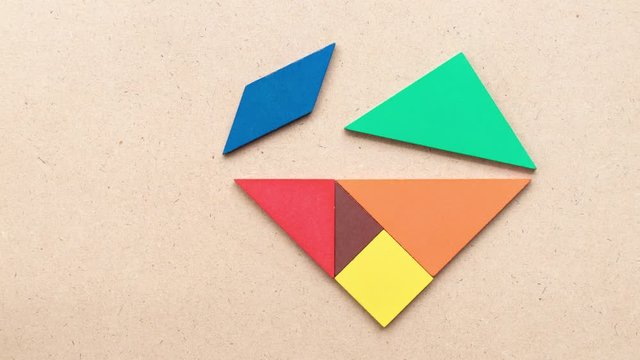 tangram puzzle composite into heart shape on wood background (Concept for love)