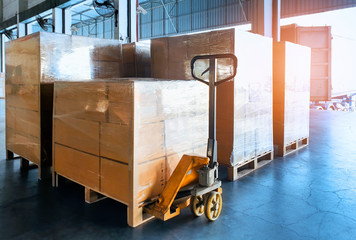 Packaging Boxes on Pallets Racks with Hand Pallet Truck in Storage Warehouse. Supply Chain....