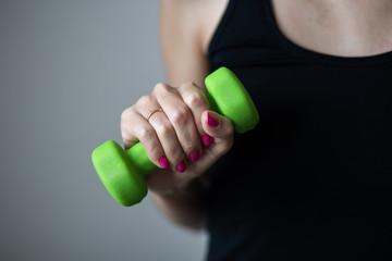 Woman holds a small dumbbells, close up photo, sport and recreation