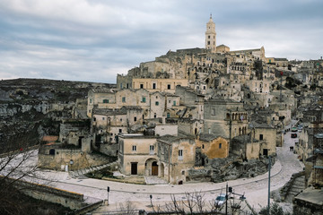 Fototapeta premium High view of of old matera town,italy,people and cars,traditional stone houses