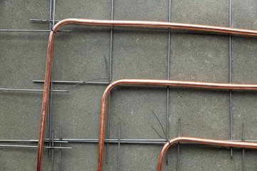 Bent new copper pipes laying on concrete floor