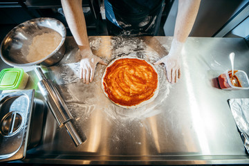 Chef starts to prepare pizza at a pizzeria