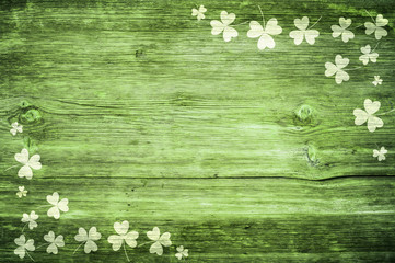 Shamrocks on green wooden table a symbol og St. Patricks Day. Bbanner with corner border of shamrocks.Textured pattern.