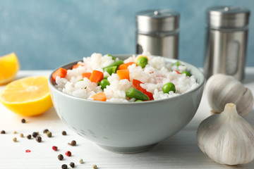Composition with bowl of delicious rice on wooden table, close up