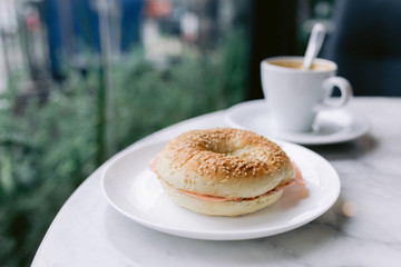 One bagel sandwich on a table in a coffee shop