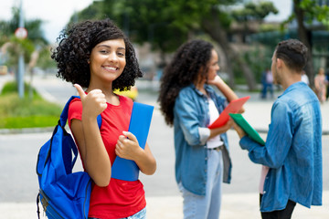 Successful arabic young adult student with group of students