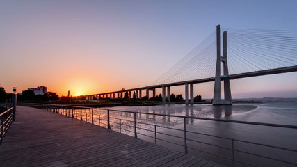 Vasco da Gama bridge during sunset and ebb-tide in Lisbon, Portugal. Timelapse