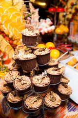 Freshly made cupcakes stand on a stand.