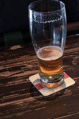 Half empty mug during drinking beer in a bar on wooden table