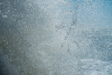 Water splash of powerful waves on blue sky background. Sea foam crashing close up , huge waves. Water texture.