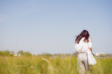 solo woman travel during take photo with greensward and clear sky background on summer season